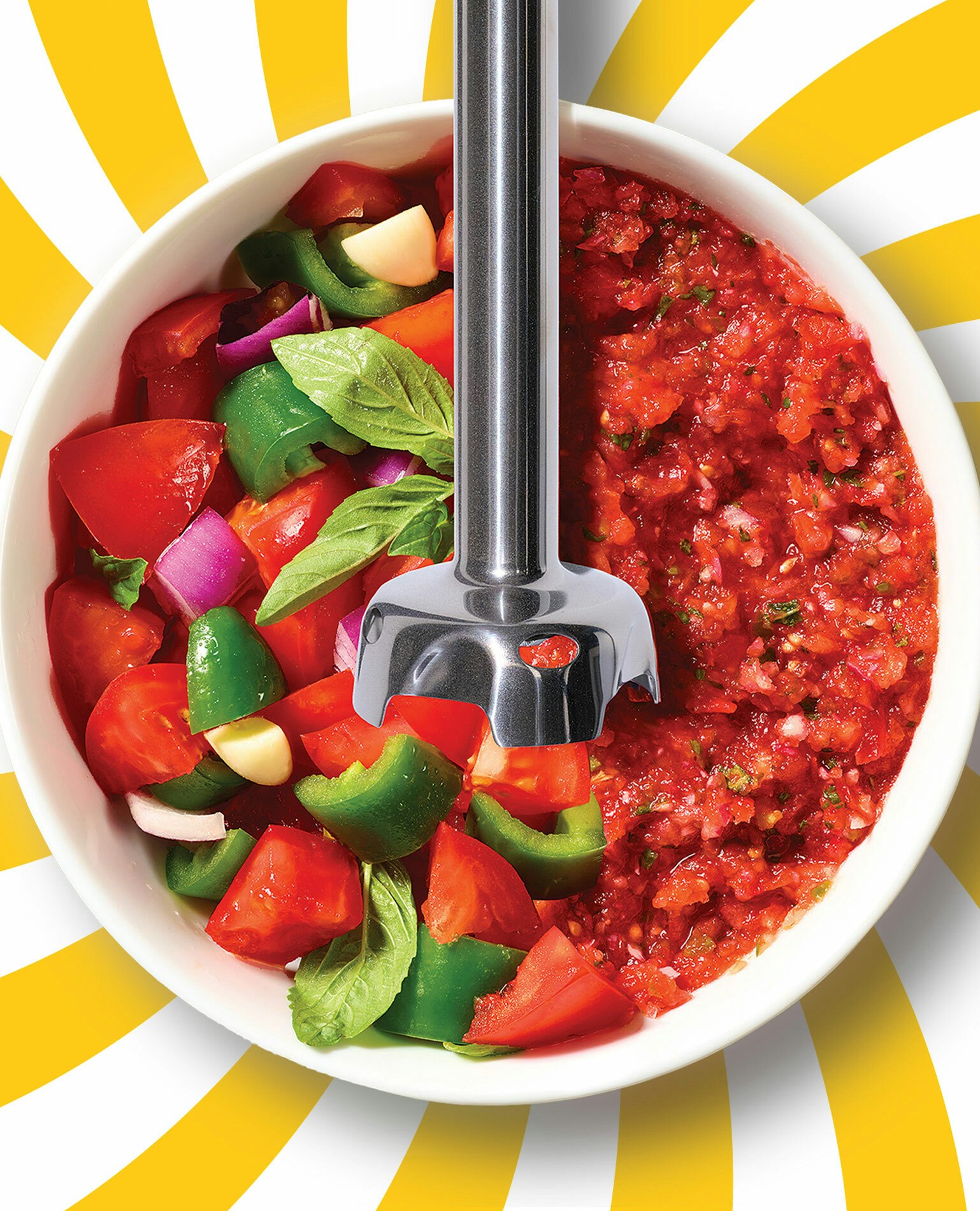 Immersion blender in a bowl of vegetables creating salsa